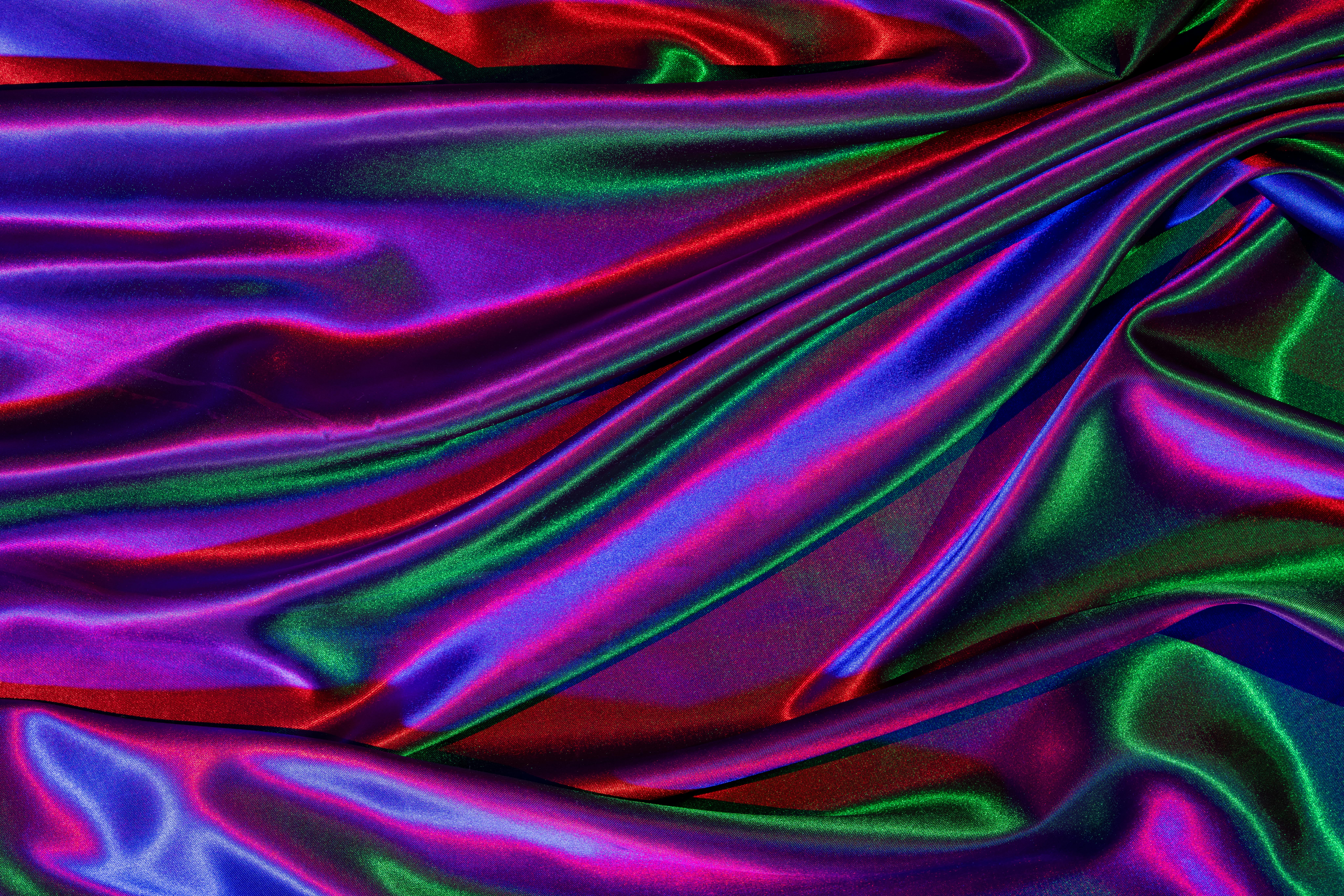 Free A close-up of vibrant, colorful satin fabric with glossy, rippling texture creating an artistic design. Stock Photo