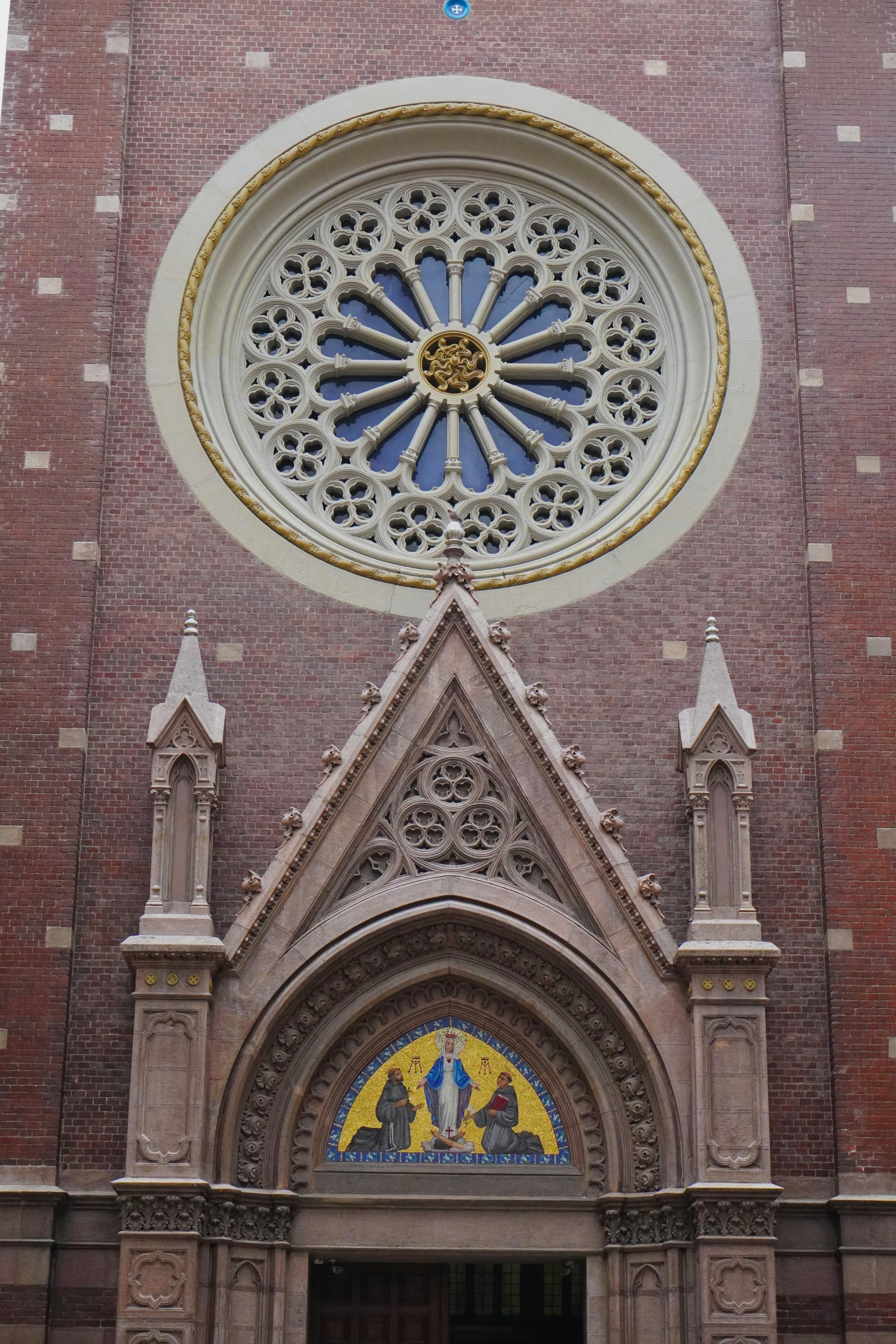 Zadarmo Detailný záber na fasádu gotického kostola s prepracovaným rozetovým oknom v tehlovej stene. Fotka z fotobanky