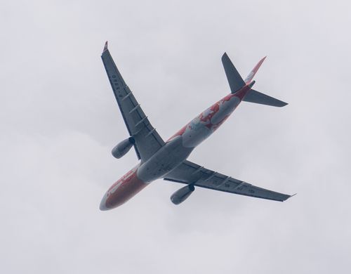 Free A commercial aircraft flying through cloudy skies, showcasing aviation dynamics and travel themes. Stock Photo