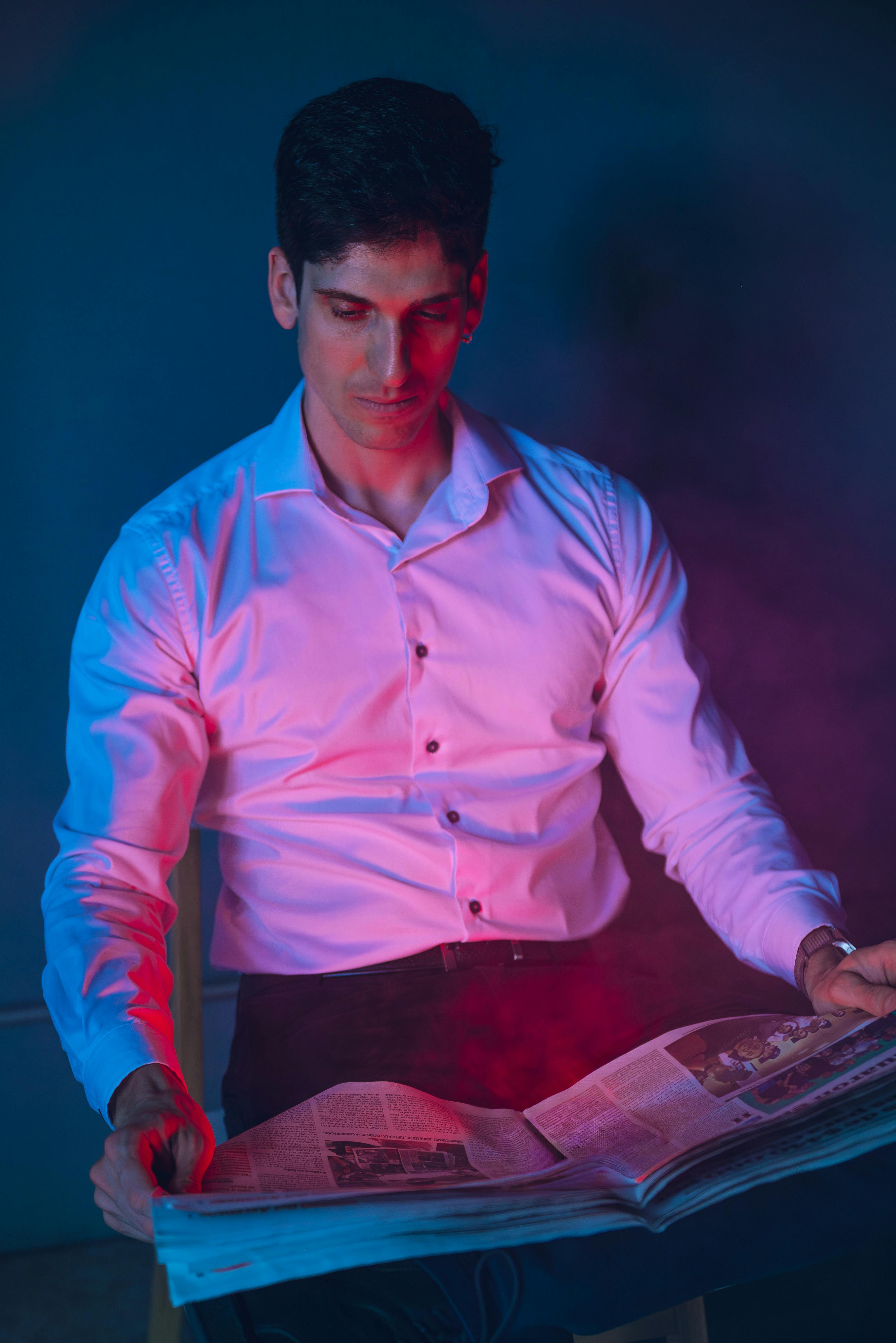 Gratis Un uomo a Buenos Aires legge il giornale sotto una creativa illuminazione colorata. Foto a disposizione