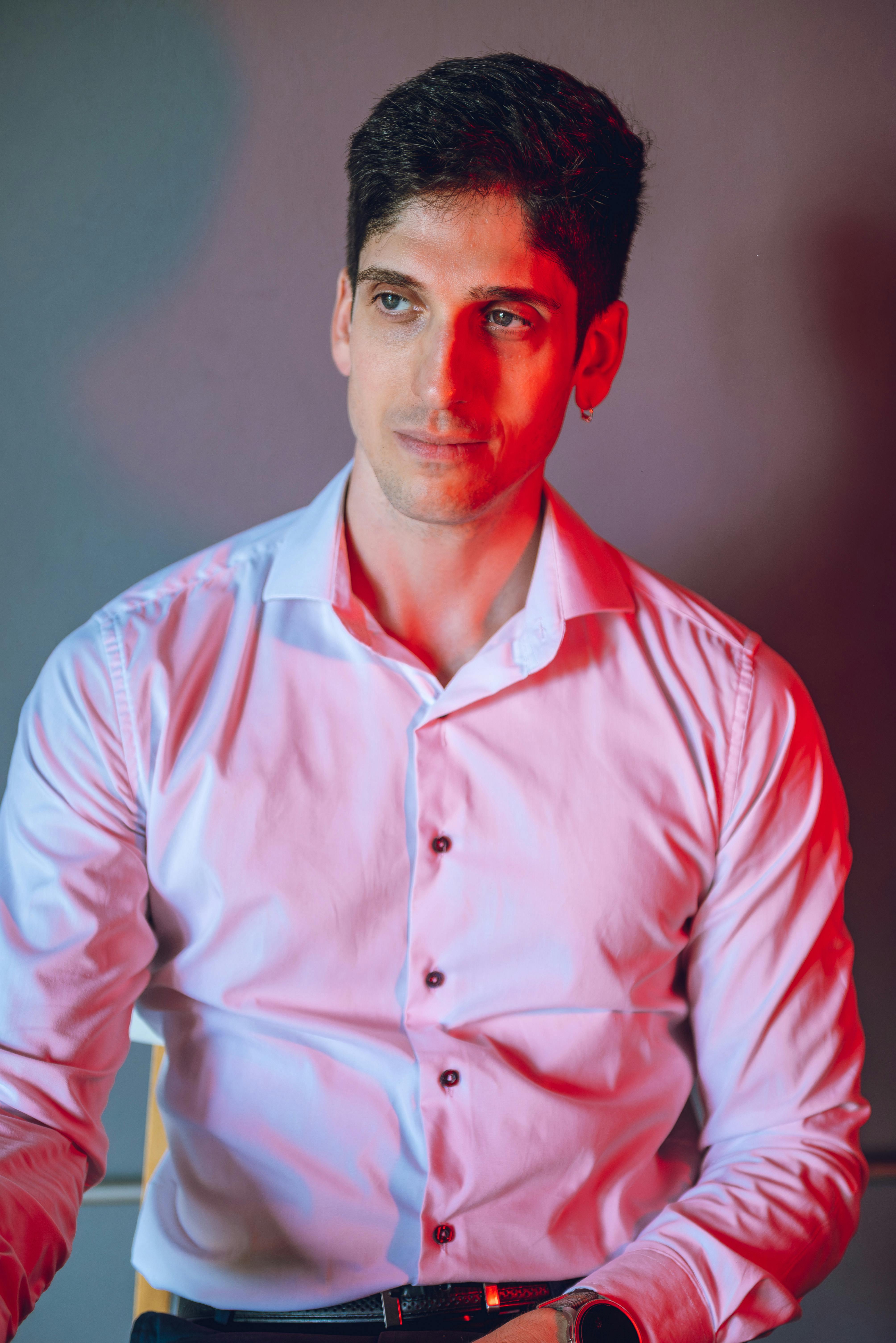 Gratis Ritratto elegante di un uomo con una suggestiva illuminazione rossa e blu in interni. Foto a disposizione