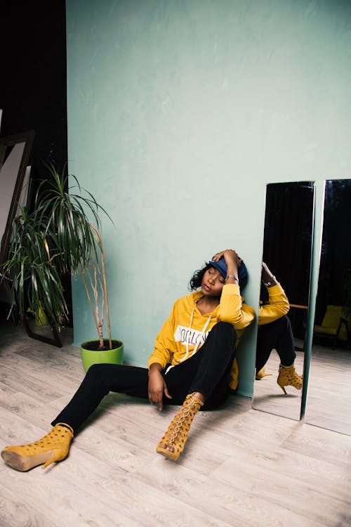 Femme En T Shirt à Col Rond Jaune Et Noir Assis Sur Une Chaise Verte