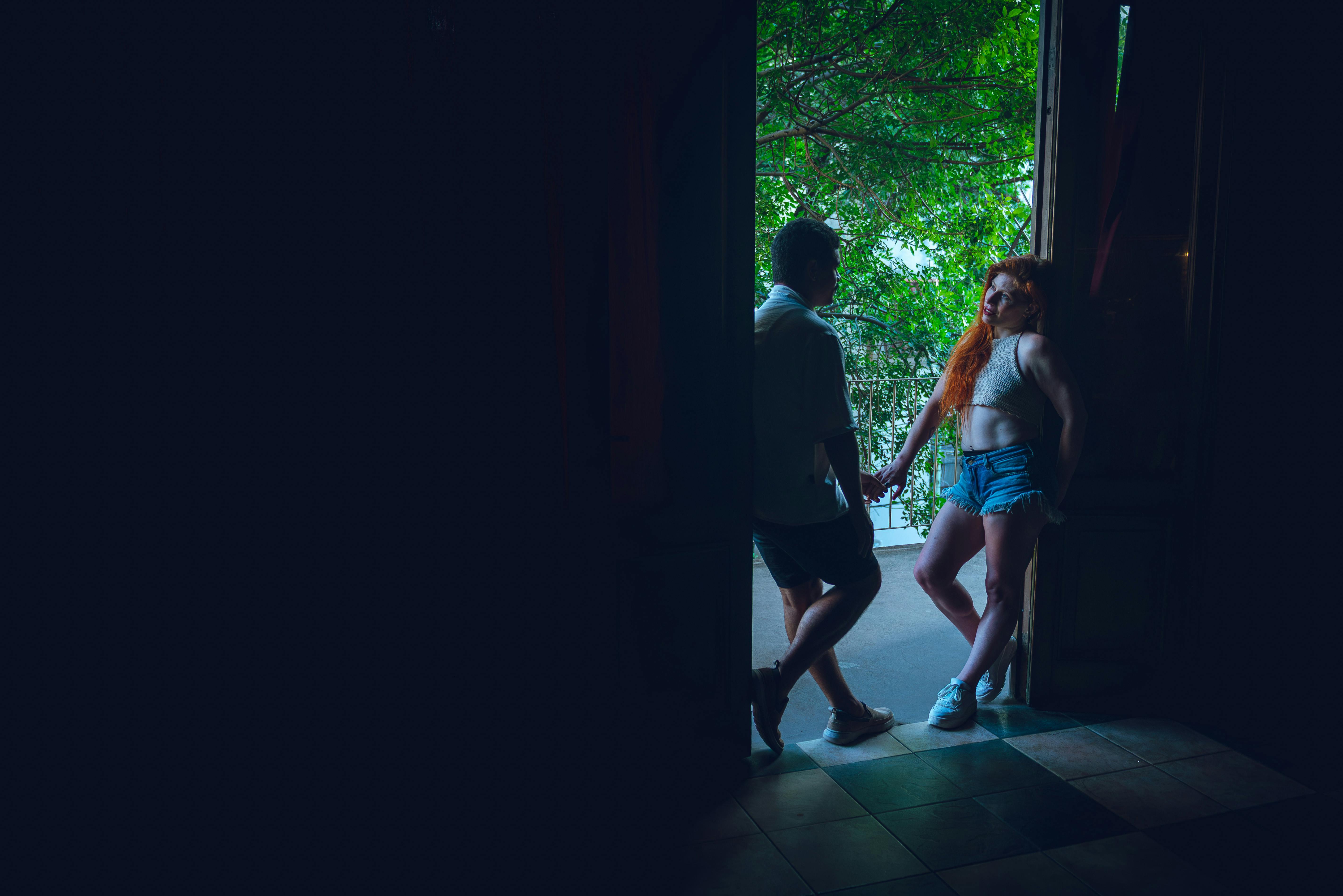 Gratis Et par deler et øjeblik nær en døråbning med frodige grønne områder udenfor i Buenos Aires. Lagerfoto