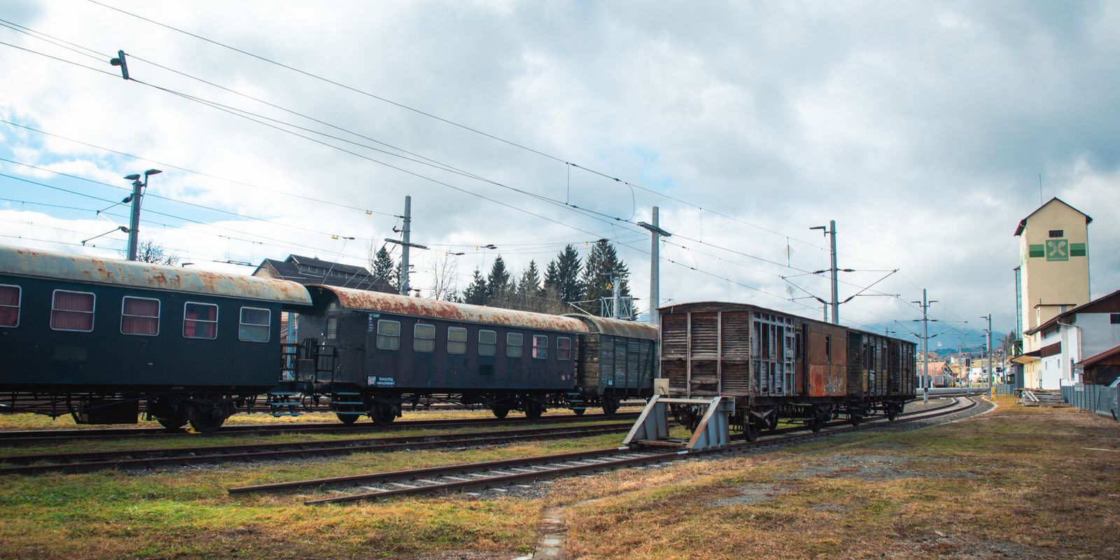 Vintage train cars parked at a scenic railway yard