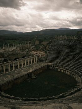 Explore the ancient Roman theatre ruins in Aydın, Türkiye with dramatic skies.