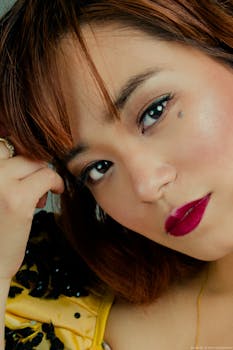 一张女人的特写肖像，她红唇引人注目，表情若有所思