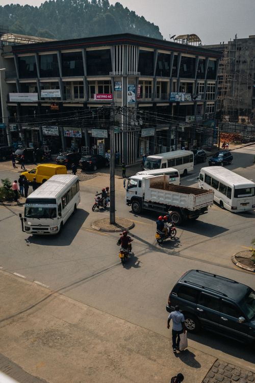 Free An urban scene capturing a bustling intersection with vehicles and people on the move. Stock Photo