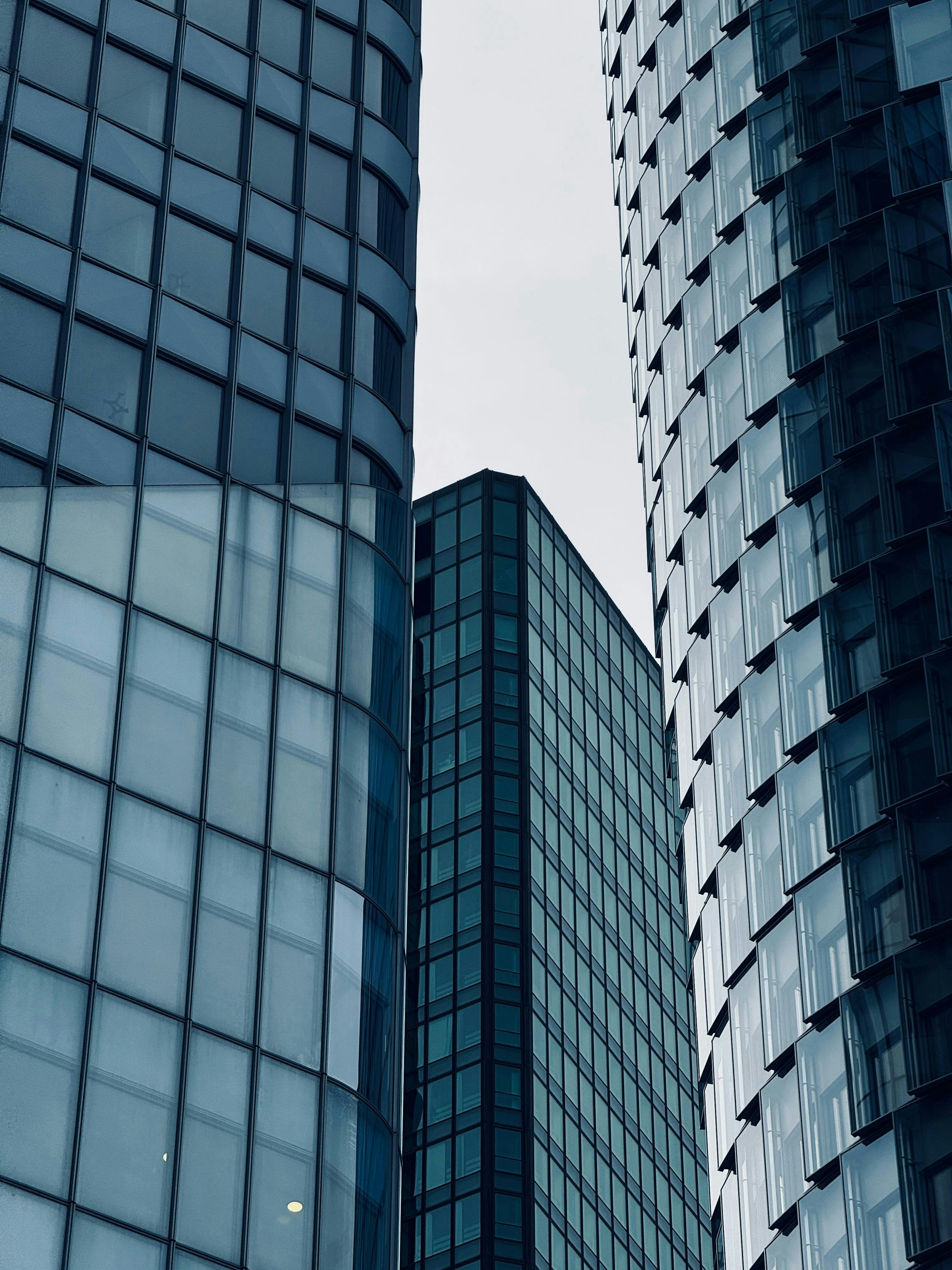 ฟรี สัมผัสกับดีไซน์ที่เรียบหรูและความสมมาตรของตึกระฟ้าในเมืองใหญ่ ด้วยผนังกระจกและรูปทรงเรขาคณิตที่เป็นเอกลักษณ์ คลังภาพถ่าย