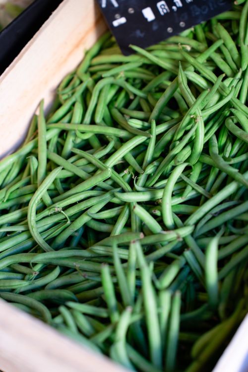 Free Close-up of fresh green beans displayed in a wooden crate at a local market. Stock Photo
