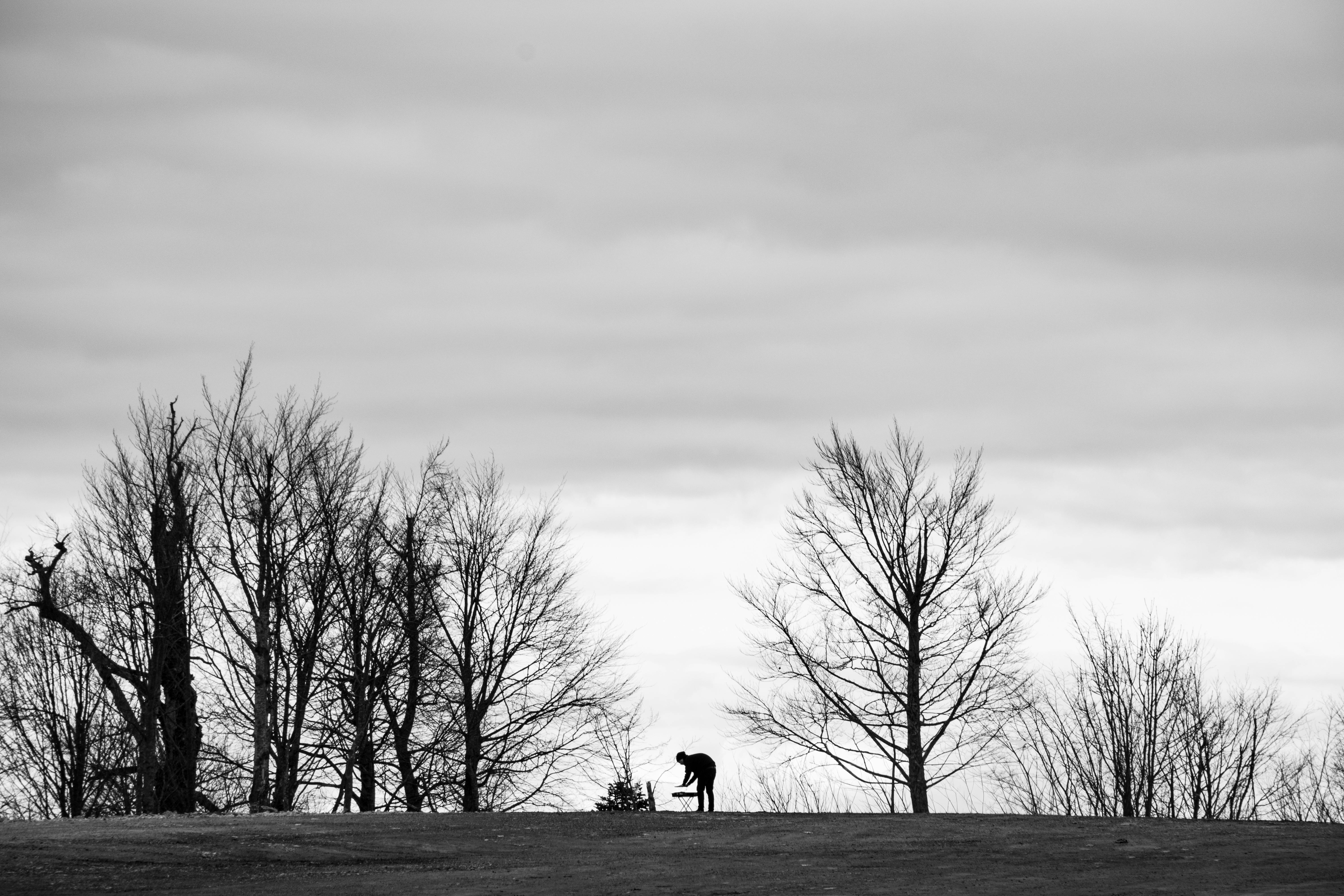 ingyenes Egy fekete-fehér kép, amely egy ember sziluettjét ábrázolja egy kopár téli tájban. Stockfotó