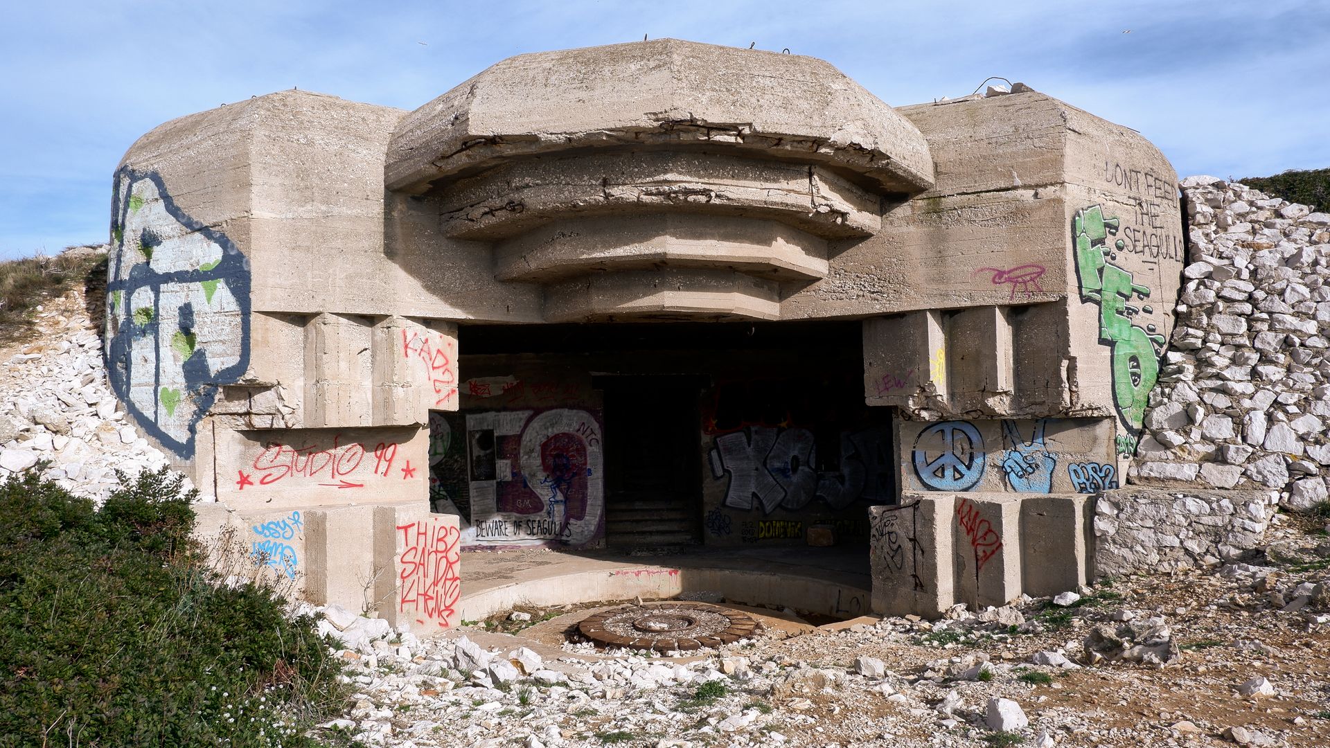 Una sección conservada de un muro de hormigón con marcas históricas