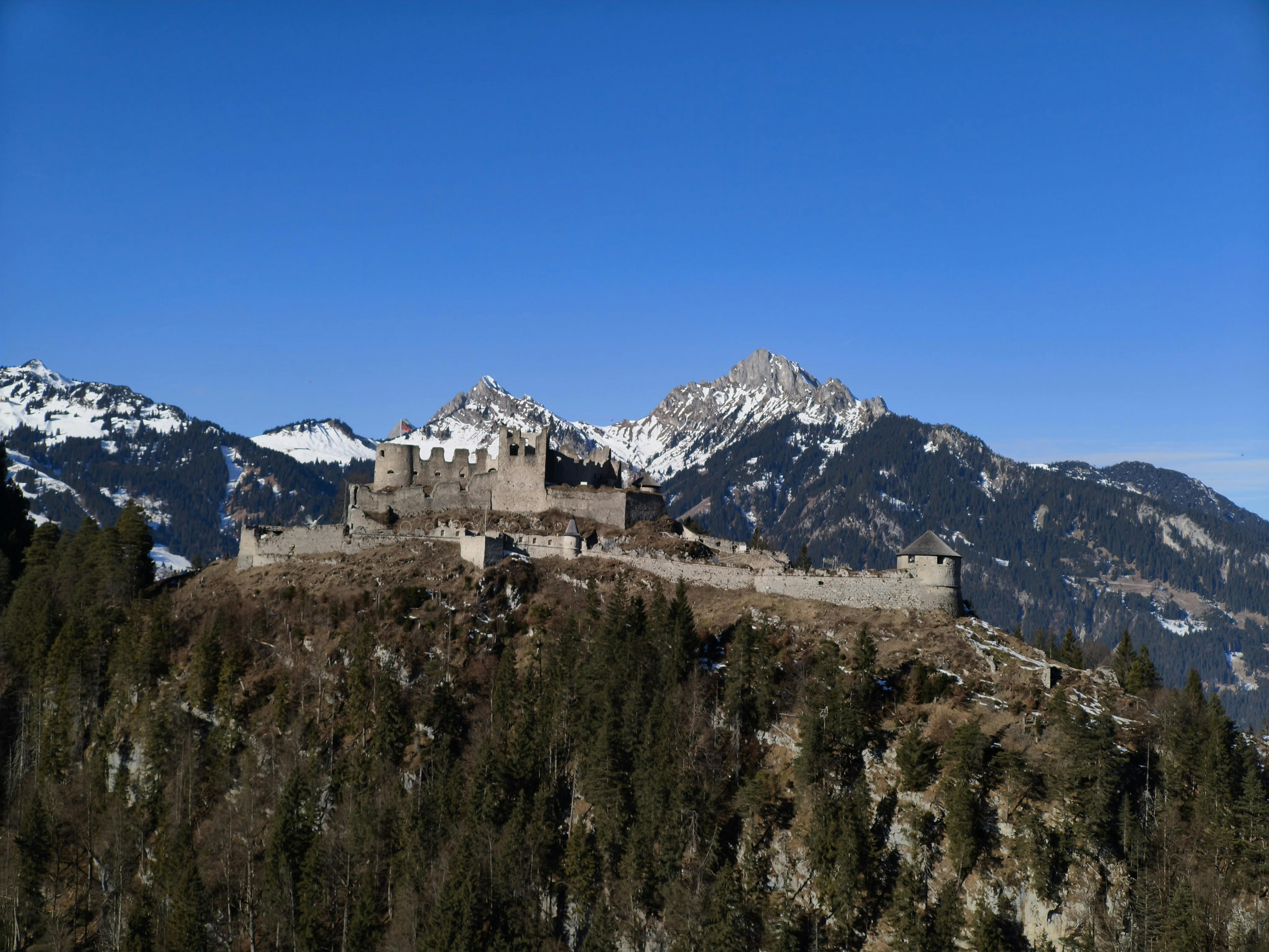 A captivating view of Ehrenberg Castle surrounded by the snowy Tyrol Alps in Reutte, Austria.