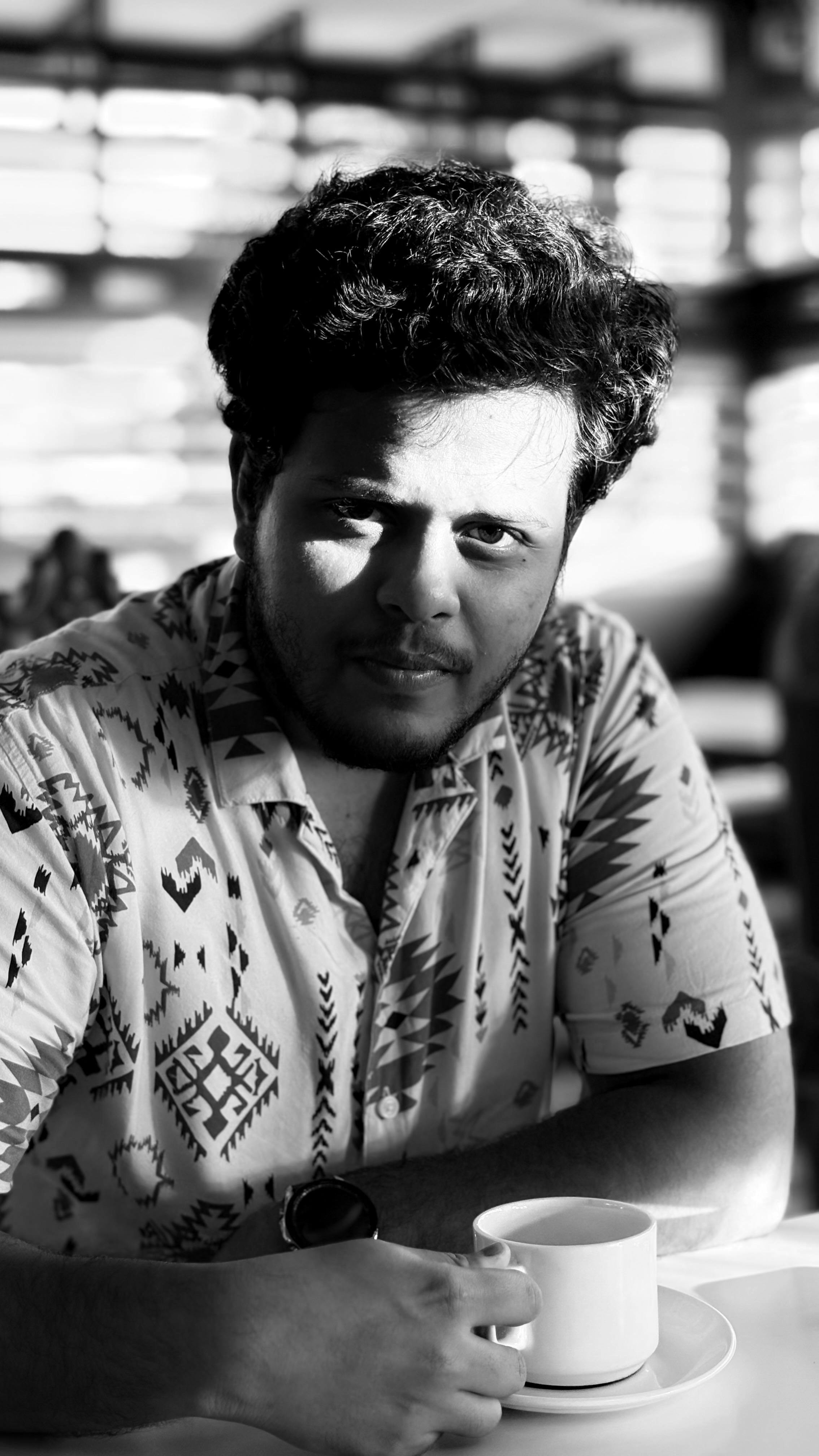 Δωρεάν Ατμοσφαιρικό ασπρόμαυρο πορτρέτο ενός άνδρα που απολαμβάνει μια στιγμή σε ένα καφέ, με εντυπωσιακό παιχνίδισμα φωτός και σκιών. Φωτογραφία από στοκ φωτογραφιών