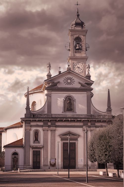 Free Beautiful facade of a historic church in Caponago, Italy under dramatic skies. Stock Photo
