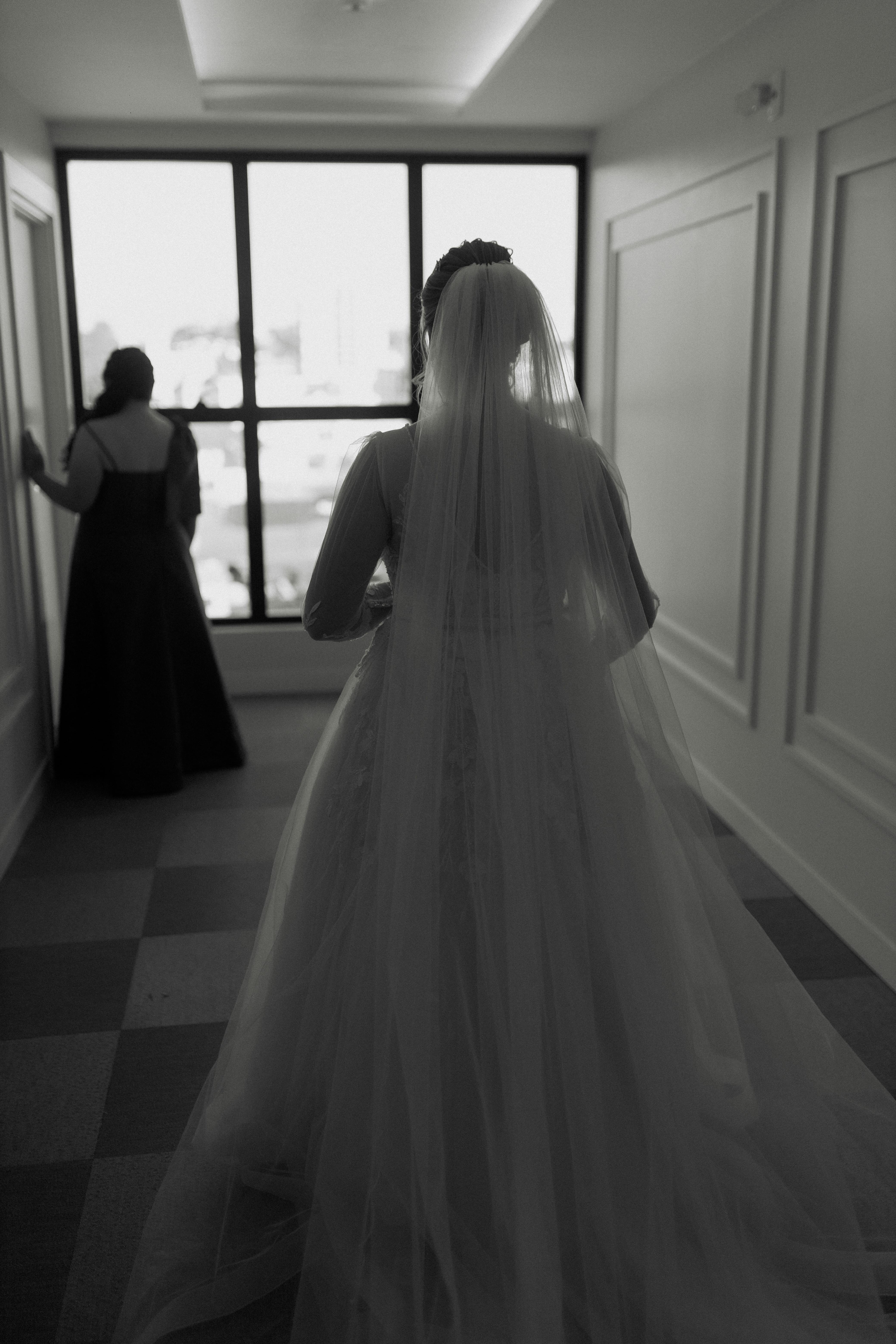 Free A stunning black and white image of a bride and bridesmaid indoors, showcasing elegance. Stock Photo