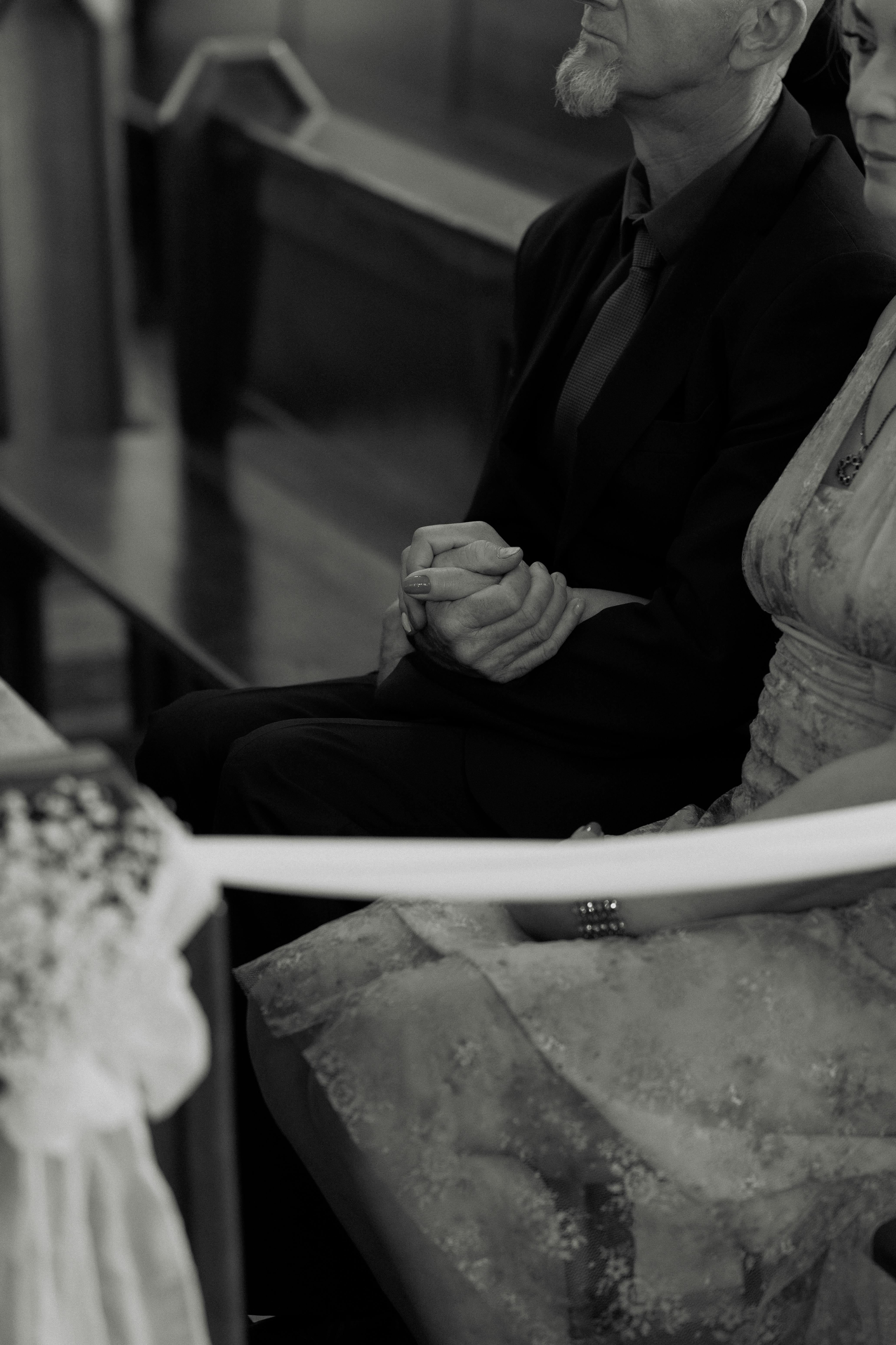 gratis Een echtpaar houdt elkaars hand vast tijdens een ontroerende huwelijksceremonie in een kerk. Stockfoto