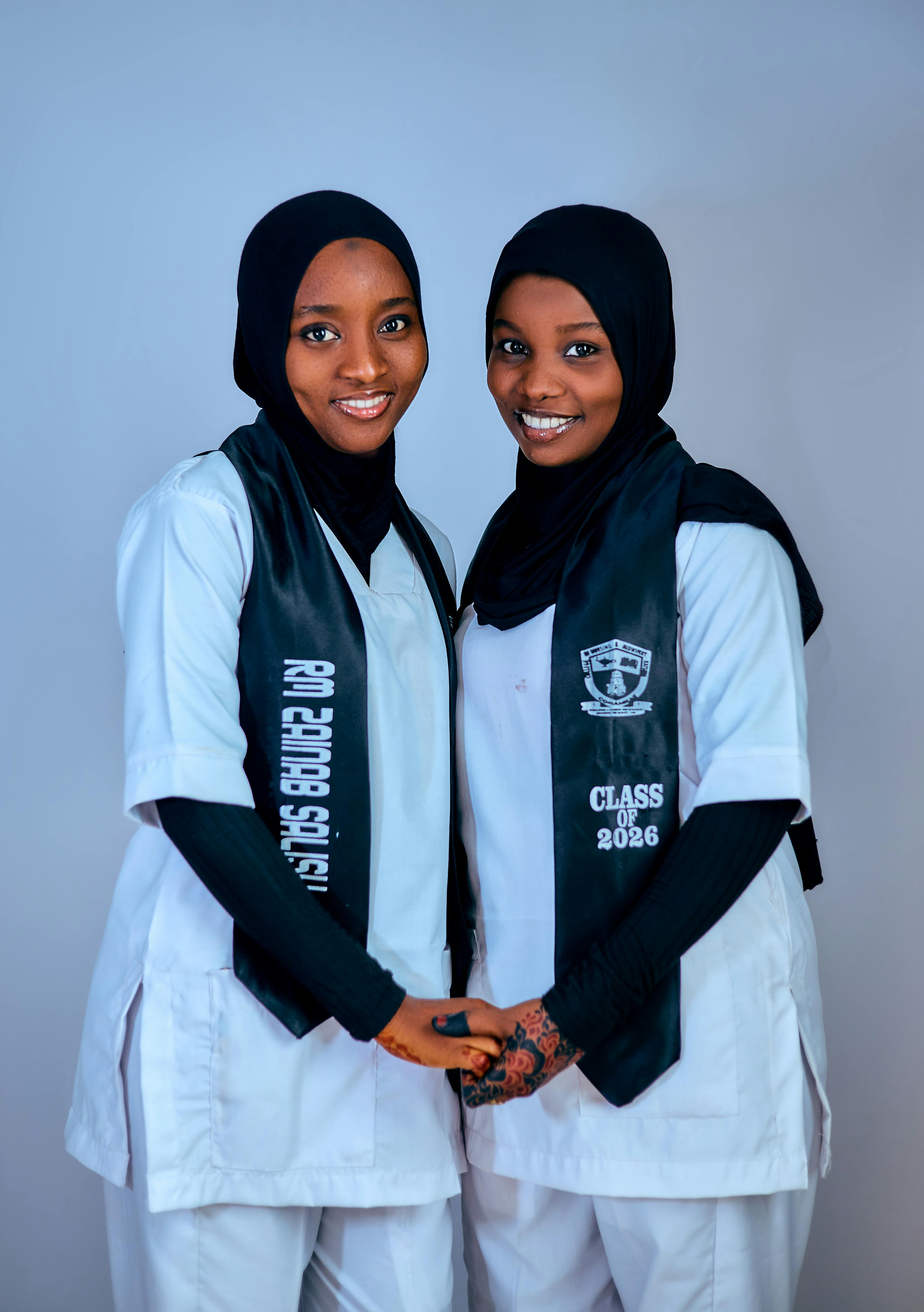 Two female nursing graduates smiling and celebrating their success.