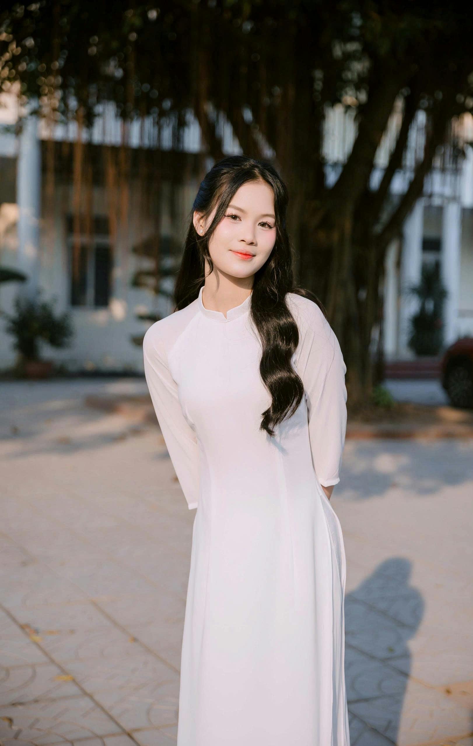 ฟรี หญิงสาวในชุดเดรสสีขาว ยืนอย่างสง่างามกลางแจ้งท่ามกลางแสงธรรมชาติ คลังภาพถ่าย