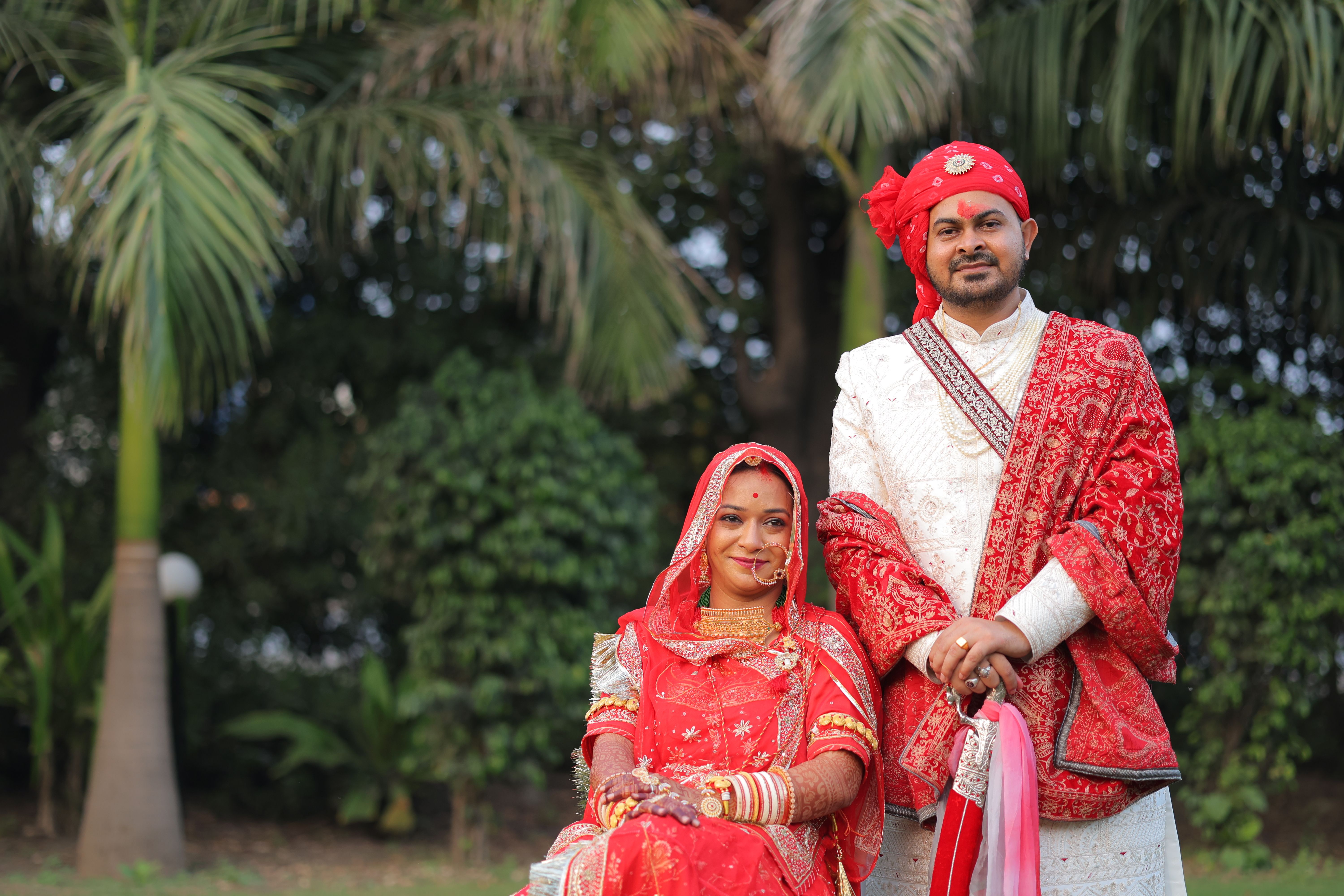 A beautiful Indian couple in traditional attire posing during an outdoor wedding photoshoot.