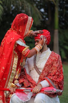 A beautifully dressed Indian bride and groom during a traditional wedding ritual outdoors.