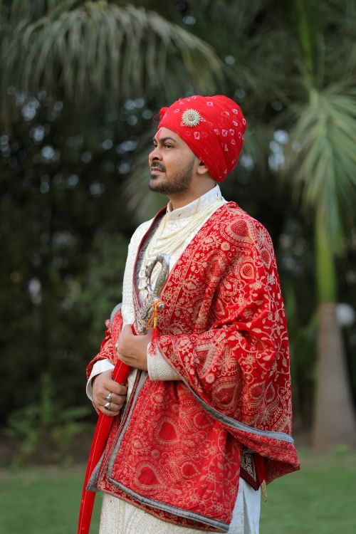 Free A groom in traditional Indian attire poses confidently outdoors. Stock Photo