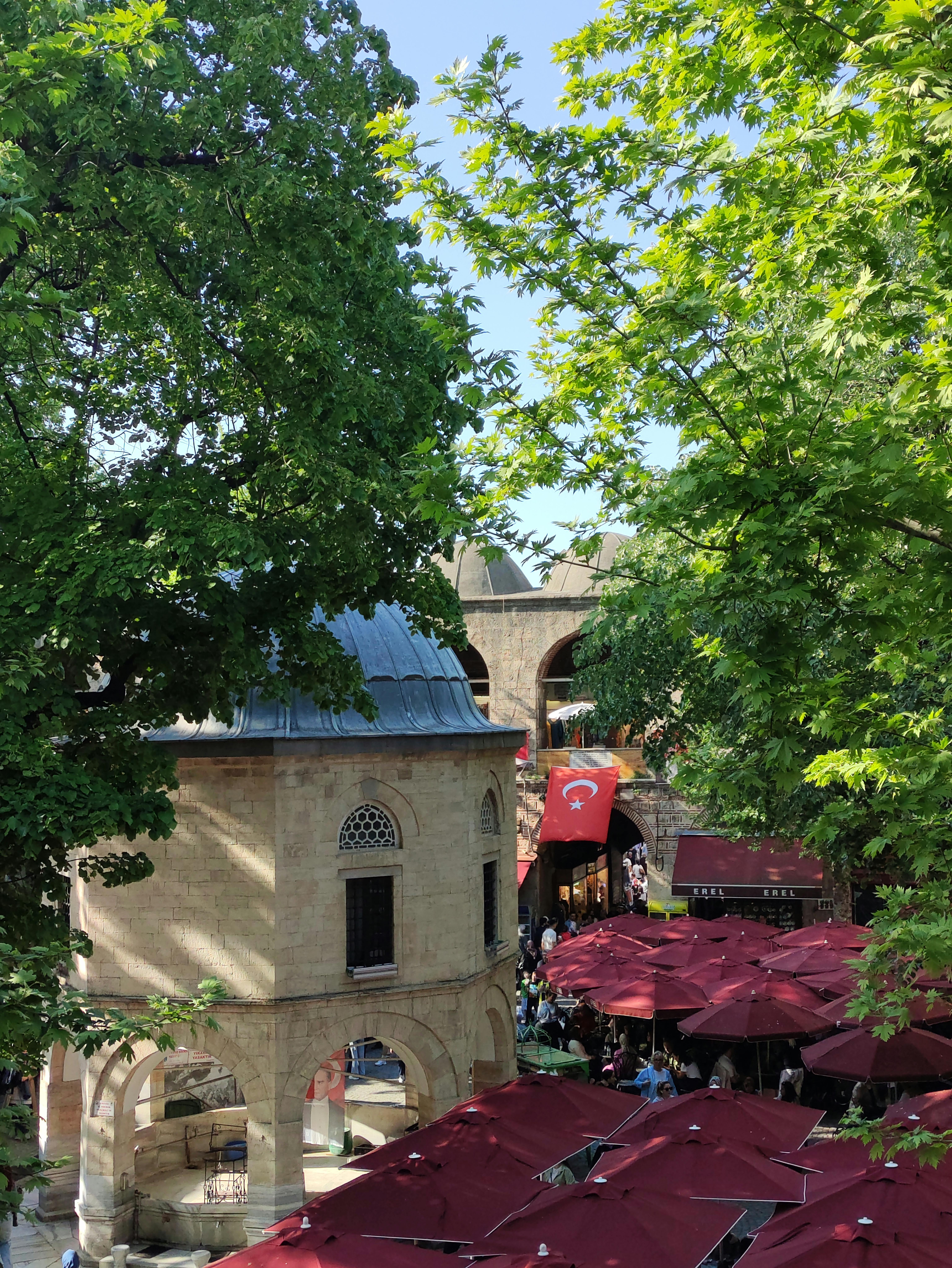 Gratis Suggestiva immagine di un cortile storico brulicante di attività, con bandiera turca e bar all'aperto. Foto a disposizione