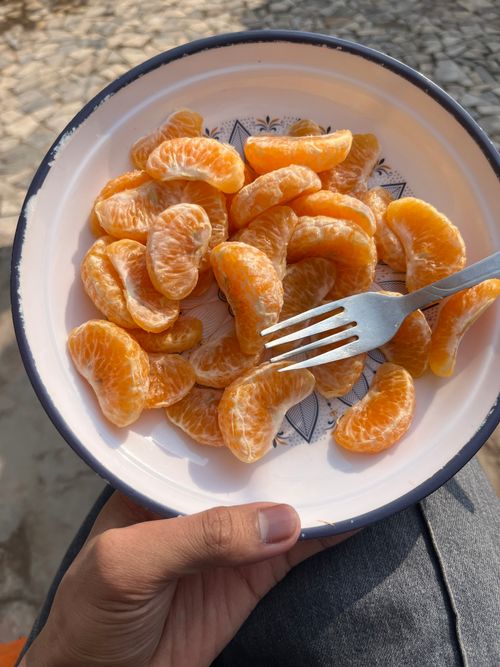 Free Fresh orange slices on a decorative plate outdoors, perfect for a healthy snack. Stock Photo