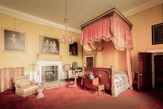 Classic vintage bedroom with a canopy bed and antique furnishings.