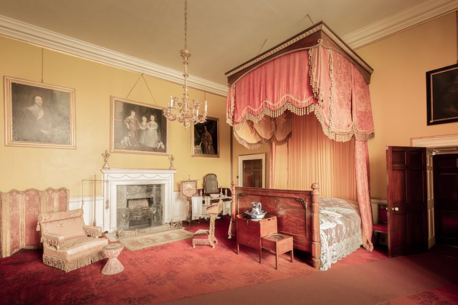 Classic vintage bedroom with a canopy bed and antique furnishings.