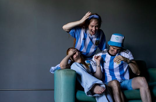 Group of friends cheering for Argentina soccer team indoors, showing excitement and support.