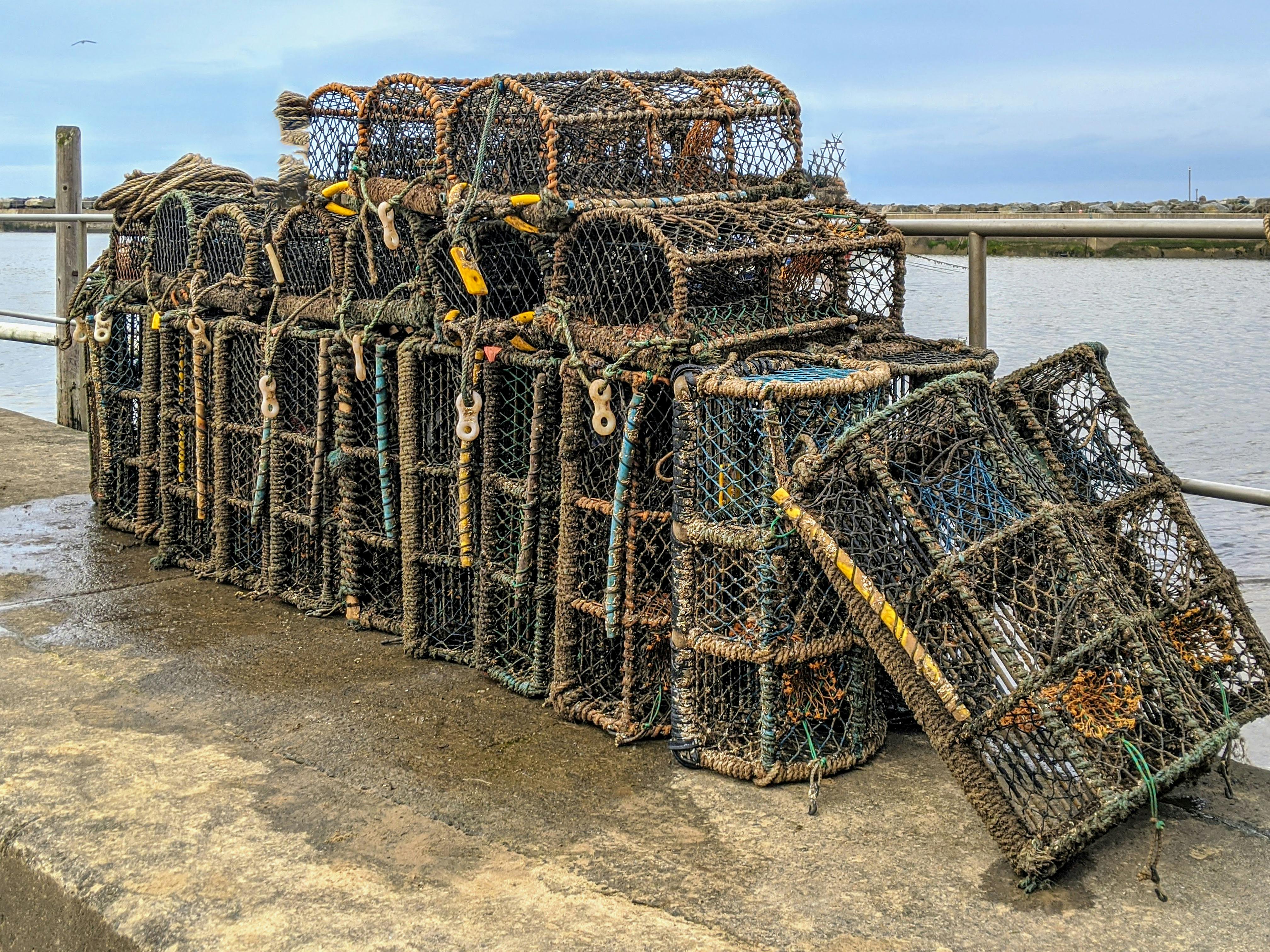 Lobster pots stacked by the water in Staithes, England, ready for fishing at the harbor.