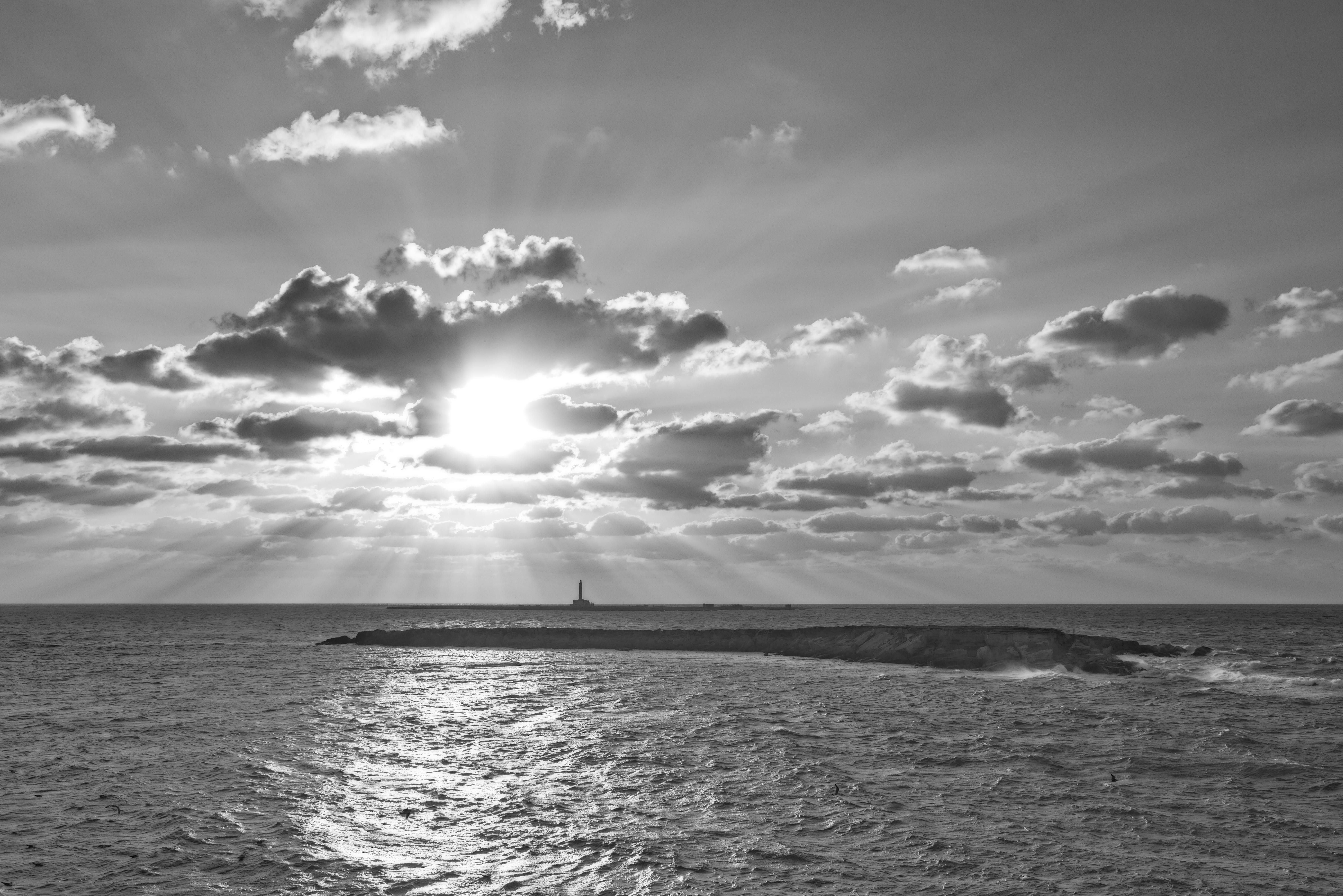 ingyenes Fekete-fehér tengeri tájkép drámai felhőkkel és naplementével az óceán felett. Stockfotó