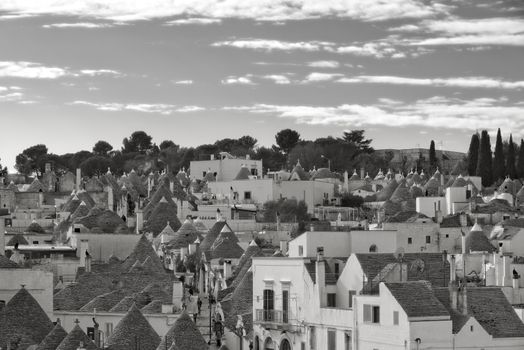 Black and white photo of iconic Trulli houses in Alberobello, Italy.