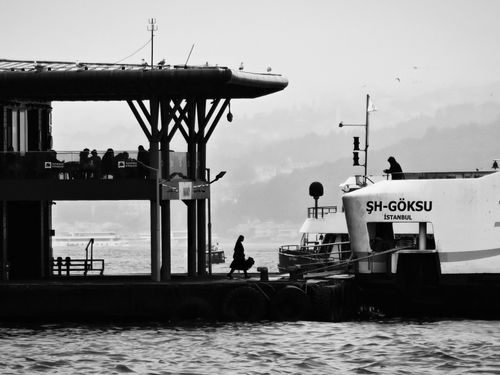 Free Silhouette of people and ferry at a dock in Istanbul, captured in black and white. Stock Photo