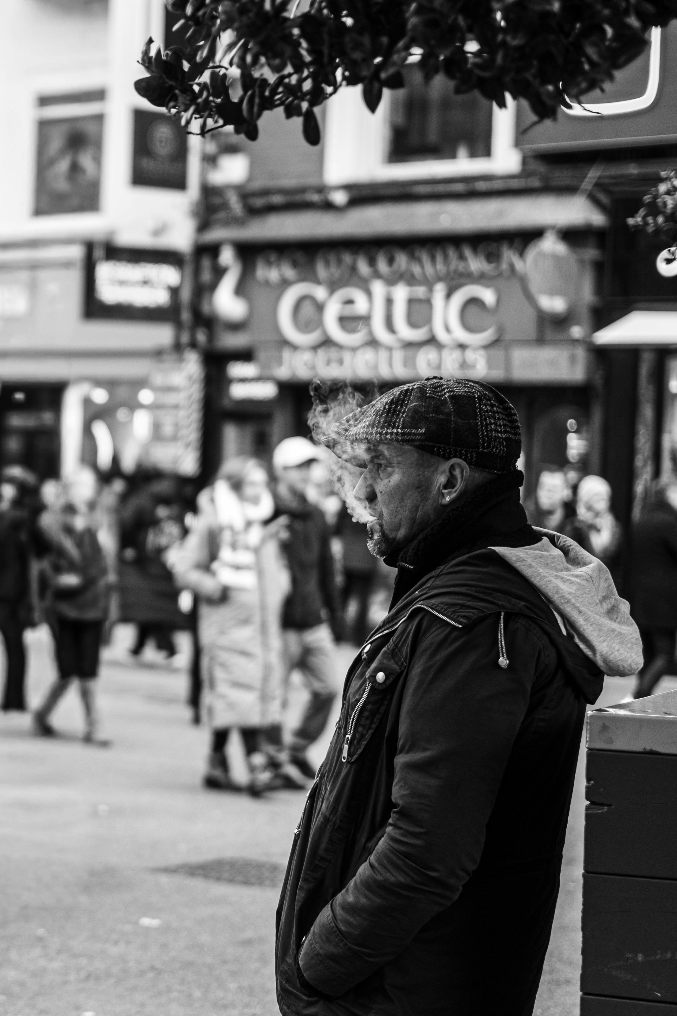 Bezpłatne Czarno-białe zdjęcie mężczyzny na ulicy w Dublinie, przedstawiające życie miejskie. Zdjęcie z galerii