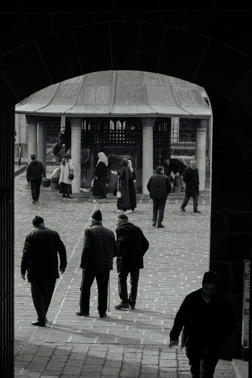 Free People walking under an archway in Diyarbakır, Türkiye, in a classic black and white tone. Stock Photo