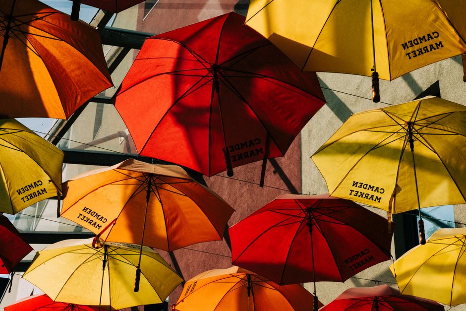 Vibrant red and yellow umbrellas at Camden Market, London, creating a lively and artistic atmosphere.