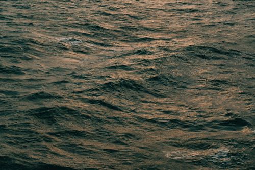 Free Serene view of ocean waves with a golden hue, captured at dusk in the UK. Stock Photo