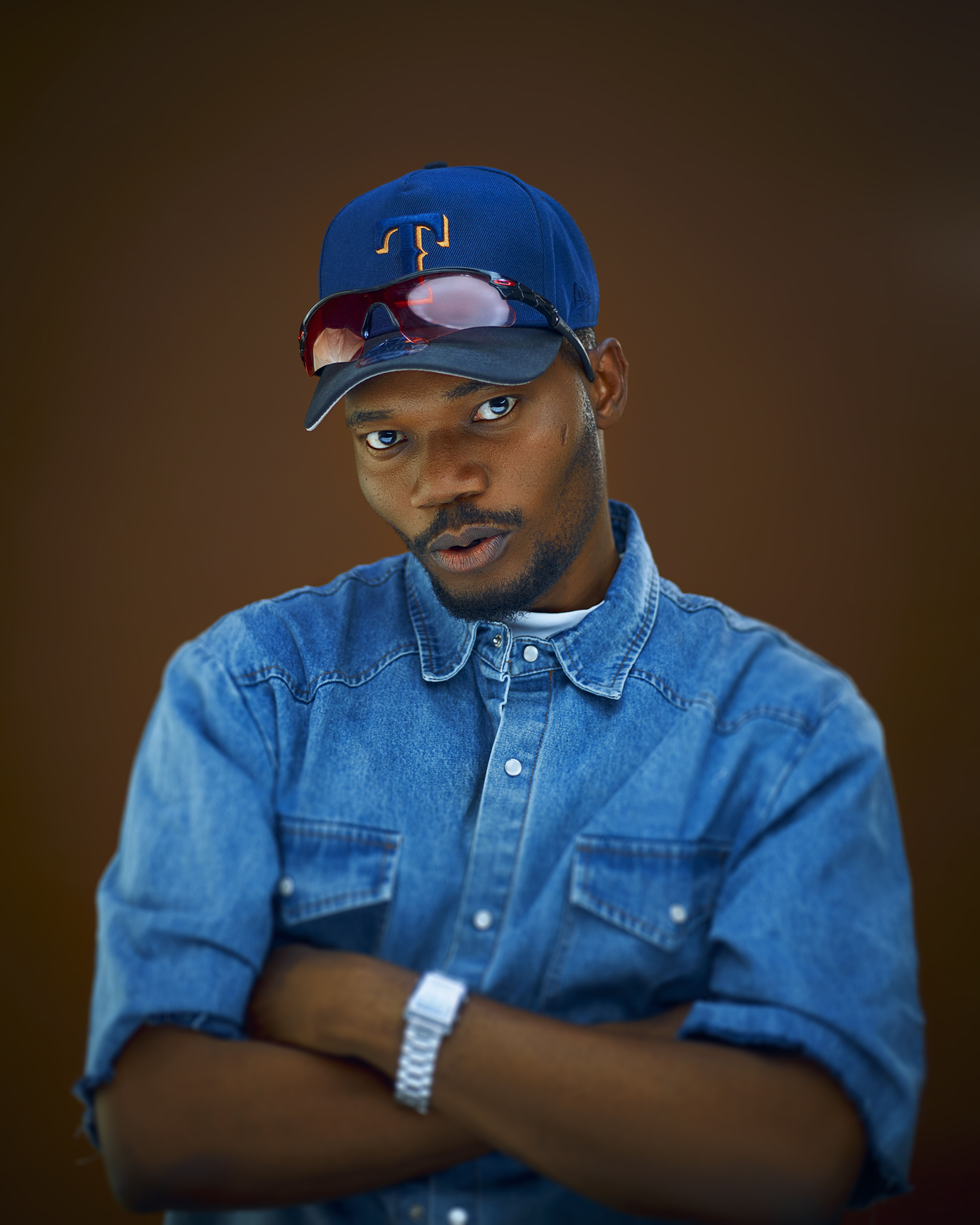 Portrait of a stylish young man wearing denim and a cap, exuding confidence.