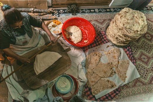 Woman preparing traditional Turkish flatbread indoors in Türkiye, showcasing cultural culinary practices.
