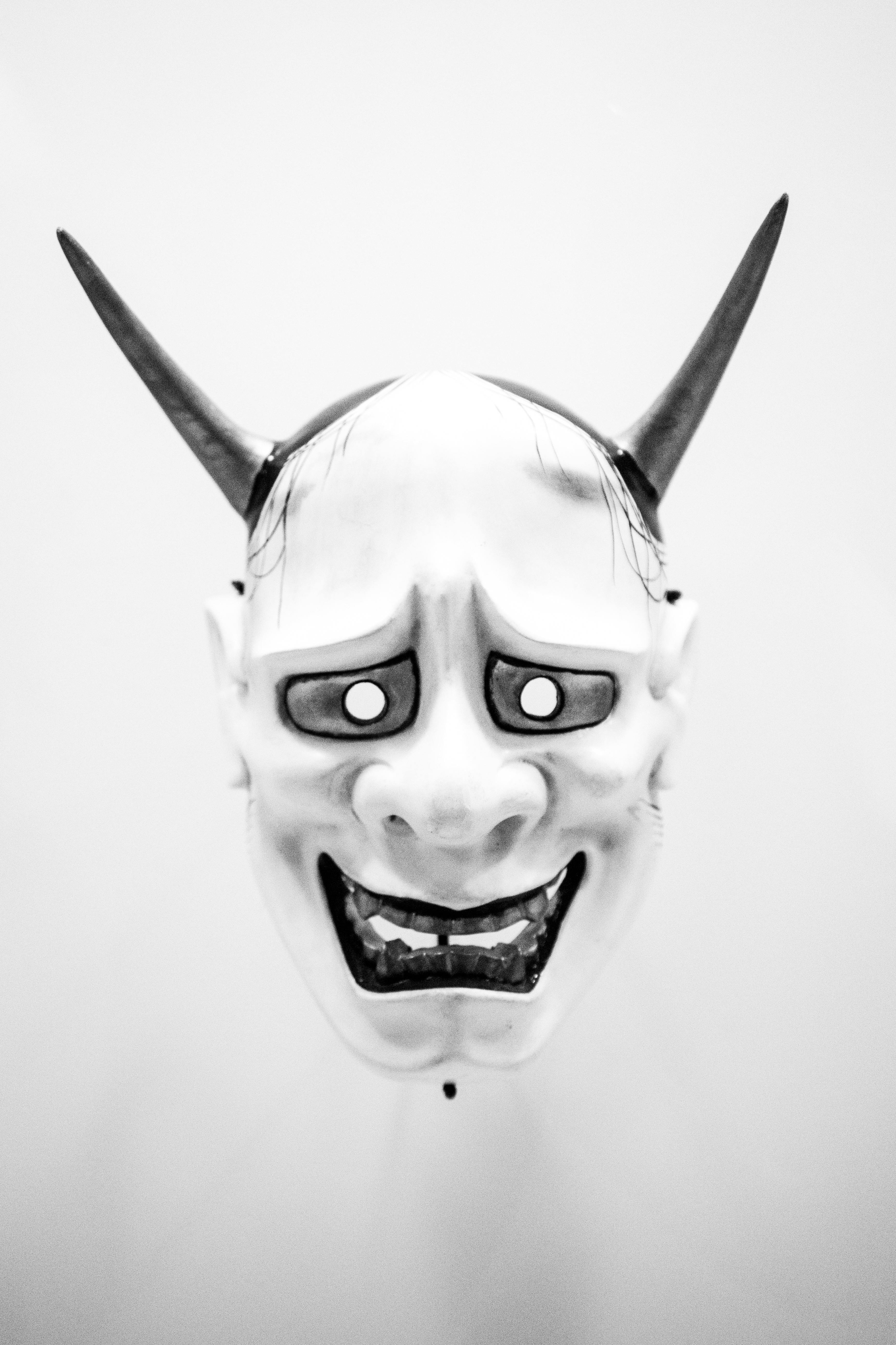 Free Traditional Japanese demon mask with expressive features in monochrome. Stock Photo