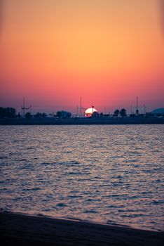 Serene sunset casting vibrant colors over a calm ocean, perfect for travel and nature inspiration.