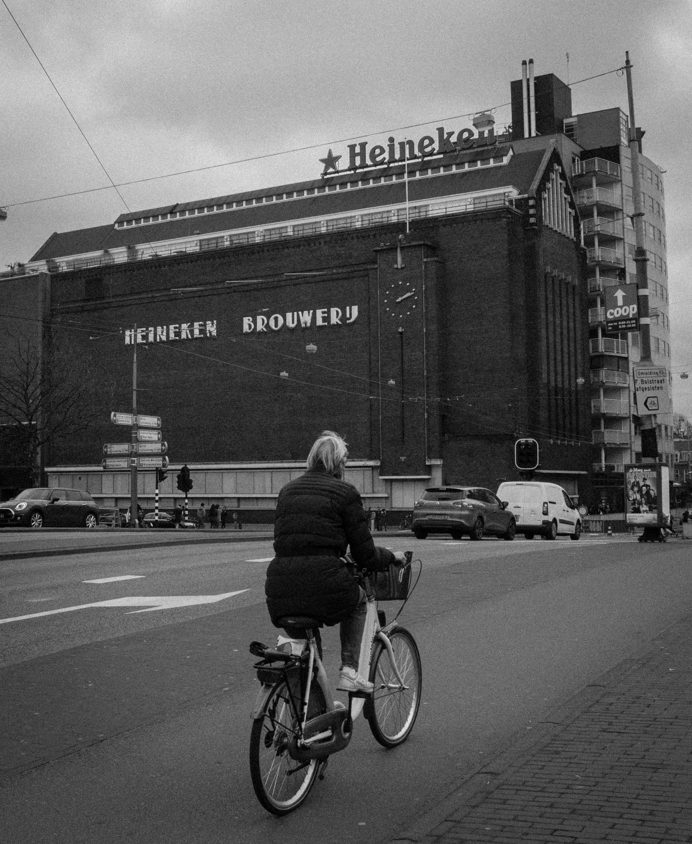 Zwart-wit foto van een fietser nabij de Heineken Brouwerij in Amsterdam.