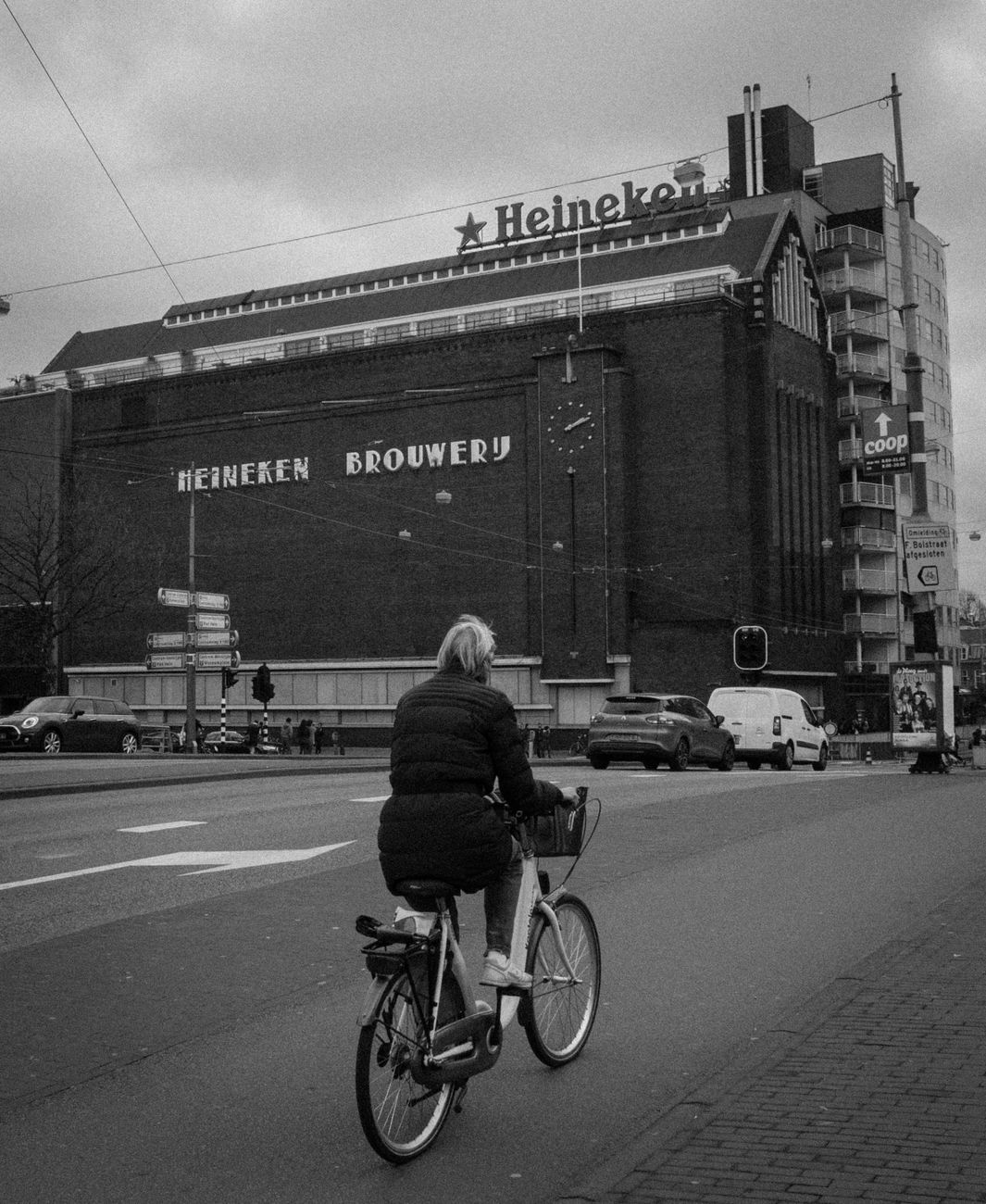Zwart-wit foto van een fietser nabij de Heineken Brouwerij in Amsterdam.