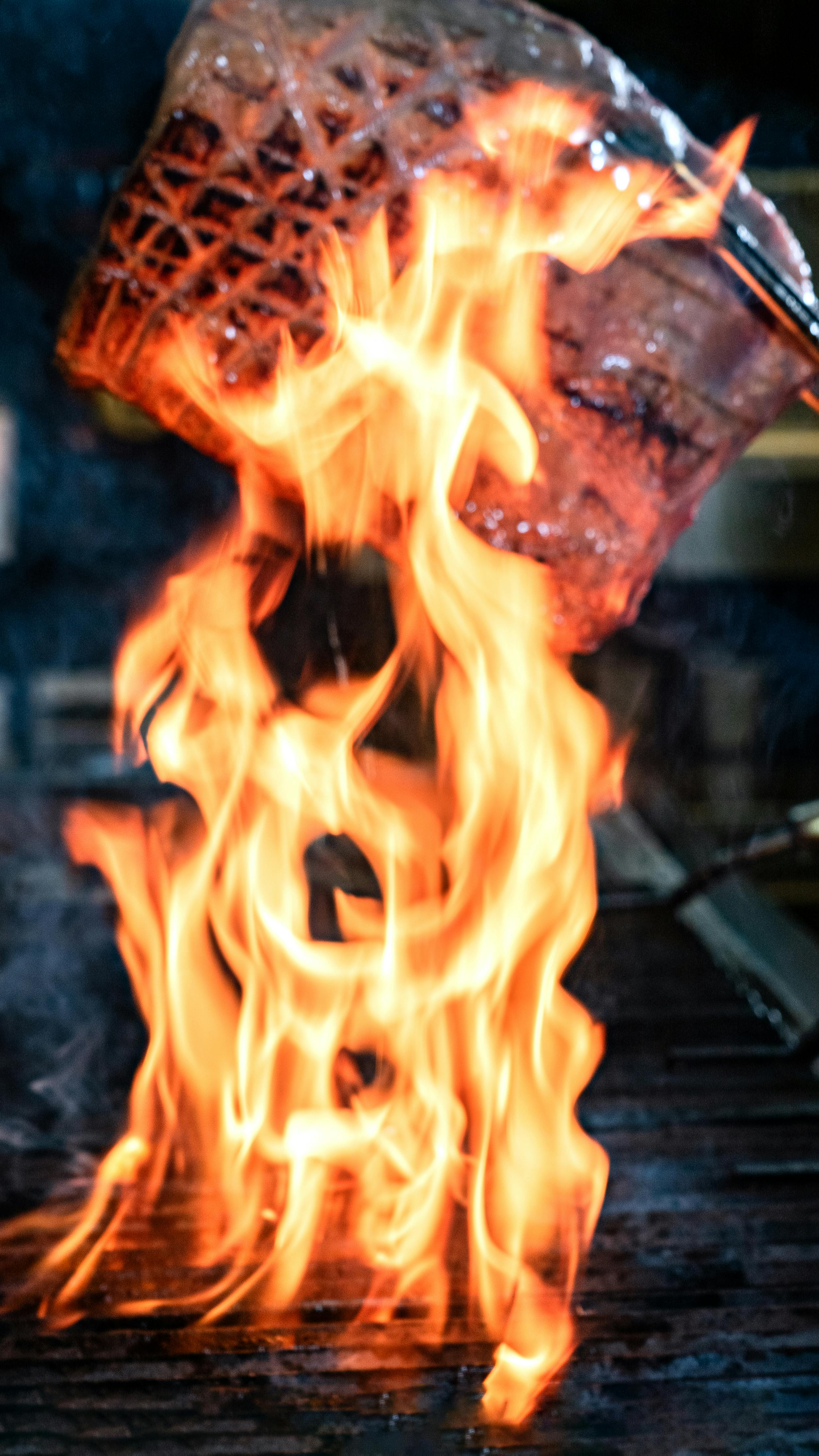 gratis Close-up van een gegrilde biefstuk met dramatisch oplaaiende vlammen. Stockfoto