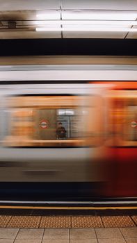 Blurred motion of a train passing through London Underground station.