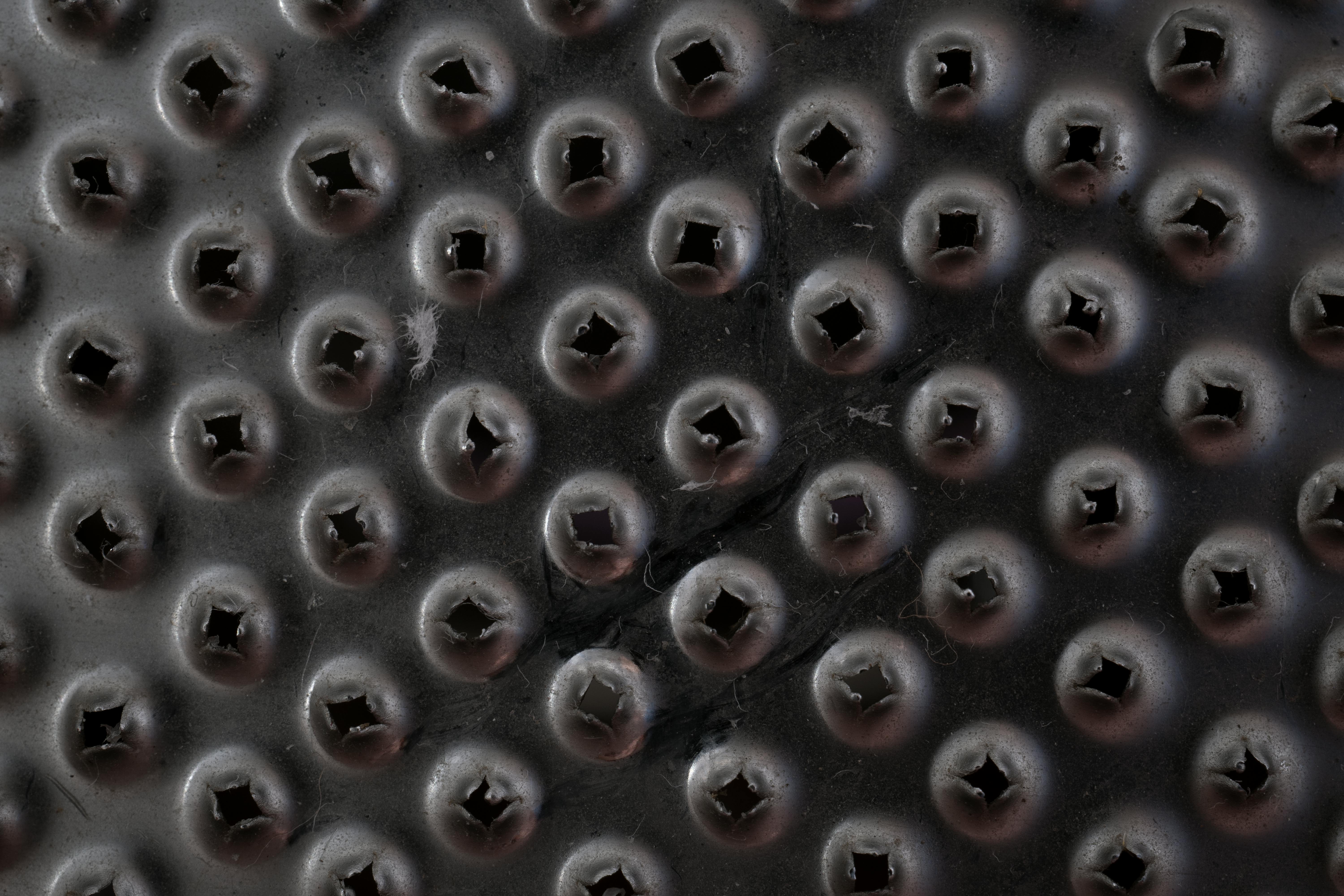 Gratuit Fotografie macro a unei suprafețe texturate negre cu modele circulare în relief și găuri mici. Fotografie de stoc