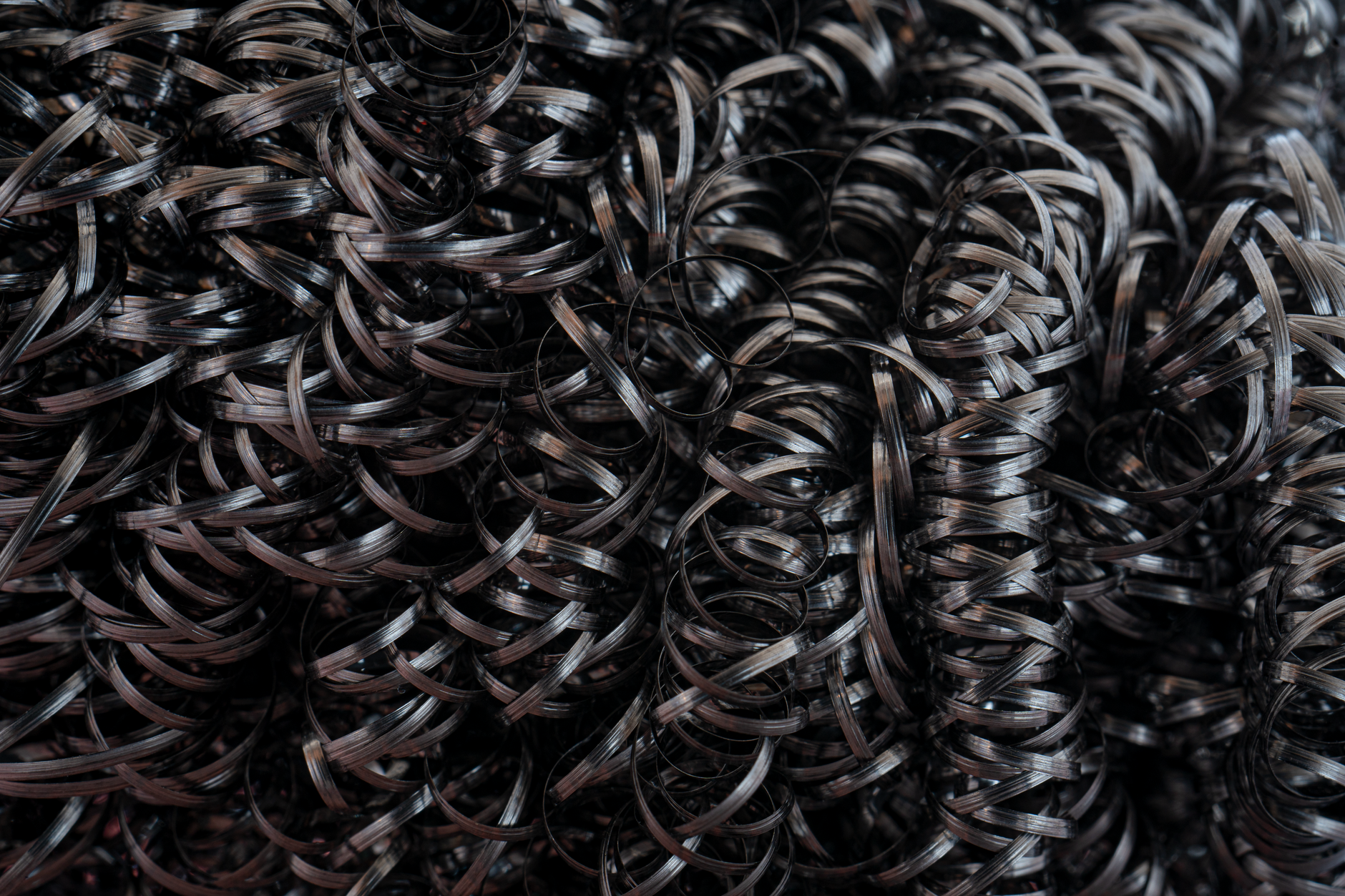 Intricate close-up of dark spiral metal shavings with a textural and abstract feel.