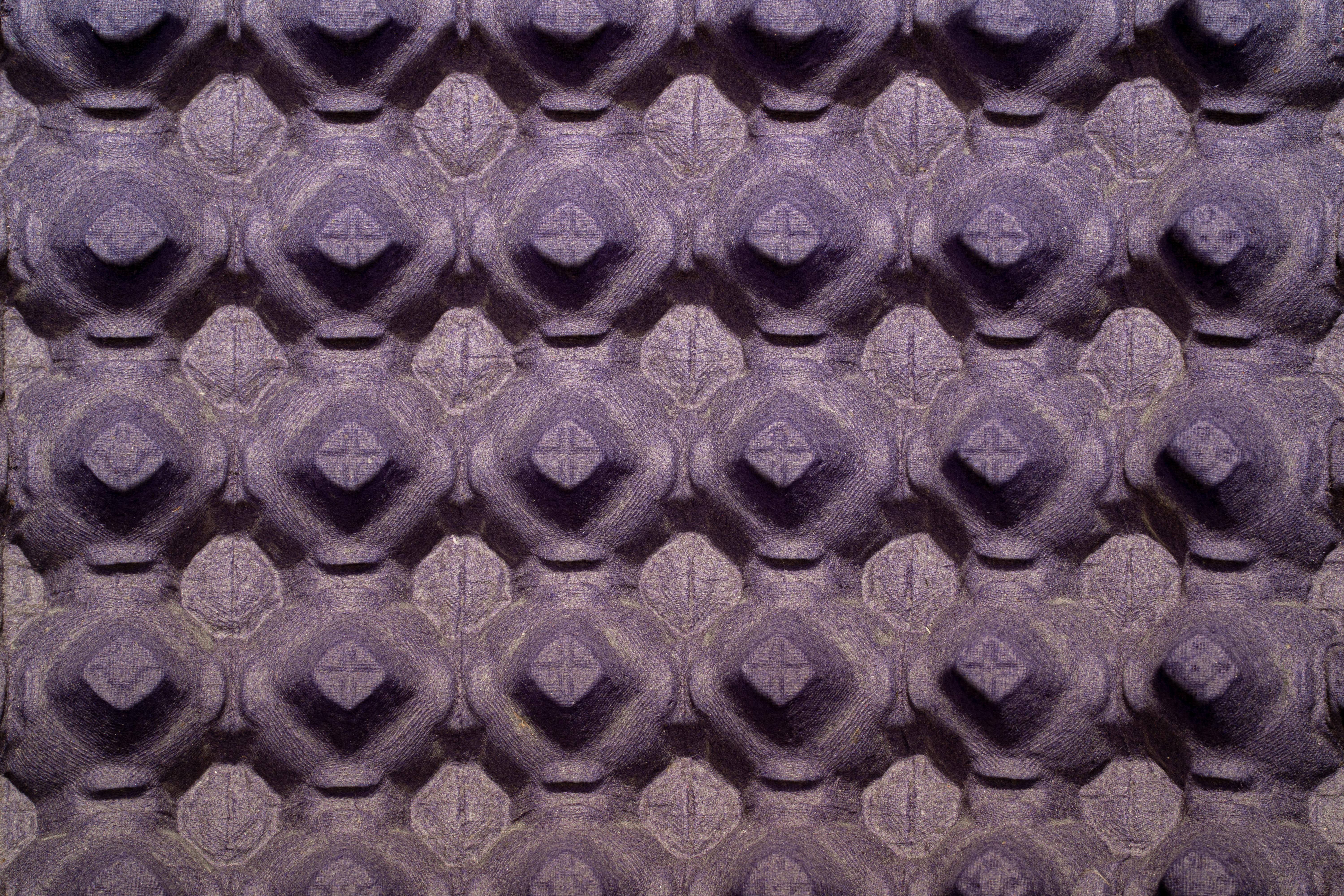 Gratuit Gros plan sur la surface texturée d'une boîte à œufs violette à motif répétitif. Photos