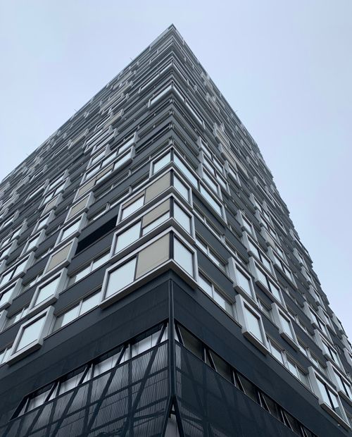 Free Dynamic view of a contemporary skyscraper façade in Zürich, showcasing modern architecture against a clear sky. Stock Photo